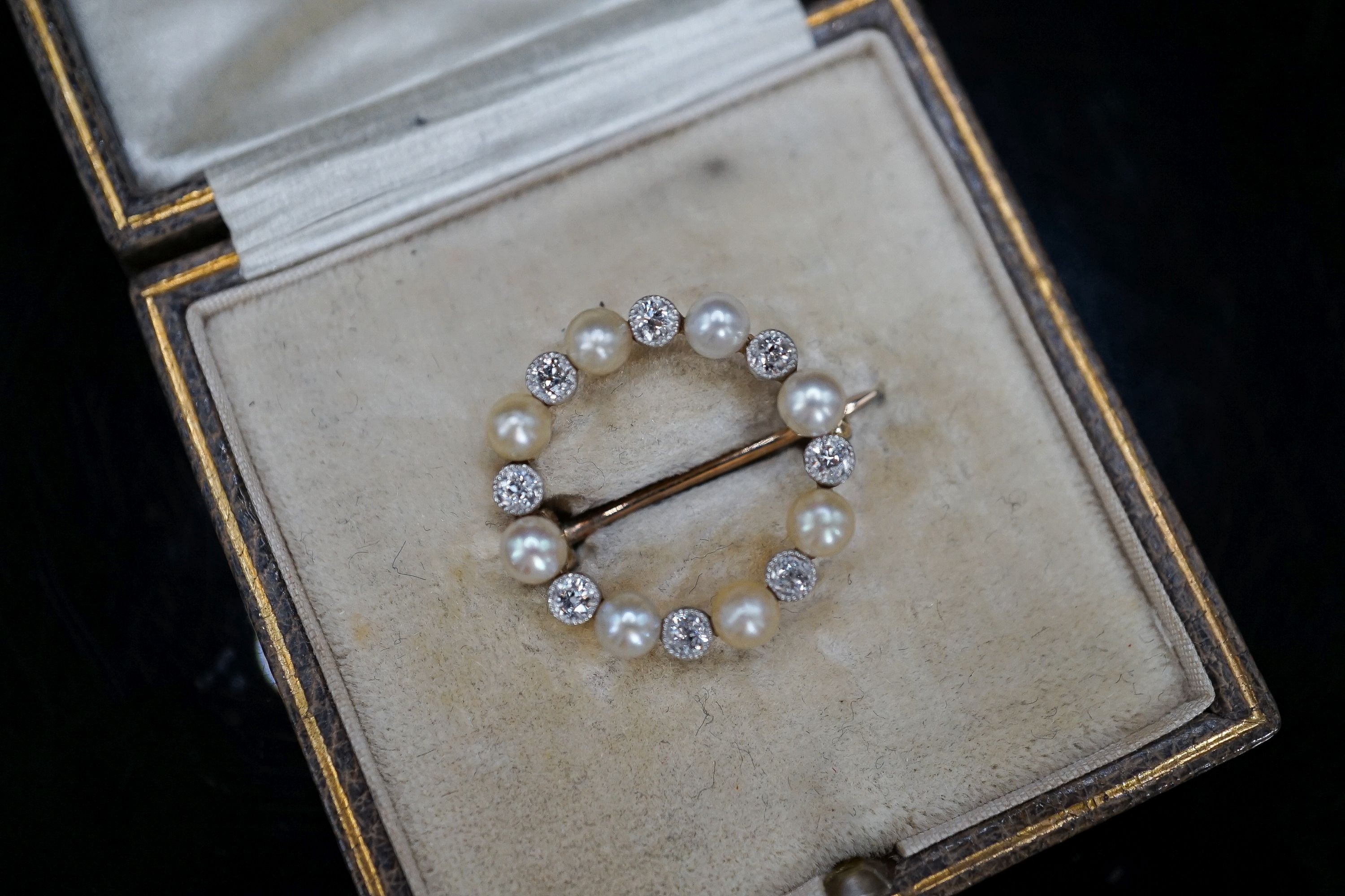 An Edwardian yellow metal, diamond and seed pearl set open work circular brooch, 20mm, gross 2.9 grams.